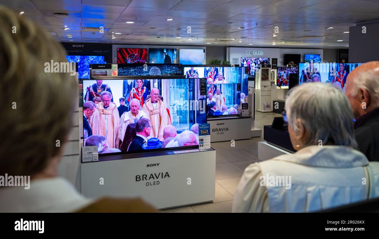 Londres, Royaume-Uni. 6 mai 2023. Les gens regardent le couronnement du roi Charles III et de la reine Camilla sur les téléviseurs grand écran au magasin phare John Lewis à Oxford Street. Il s’agit du premier couronnement du Royaume-Uni depuis 70 ans et du premier à avoir lieu à l’ère numérique. Credit: Stephen Chung / Alamy Live News Banque D'Images