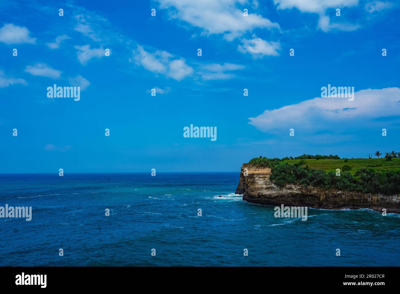 Pantai Klayar ou Plage de Klayar avec des rochers et de fortes vagues contre le ciel bleu. Flou de mouvement. Photographie de paysage. Banque D'Images