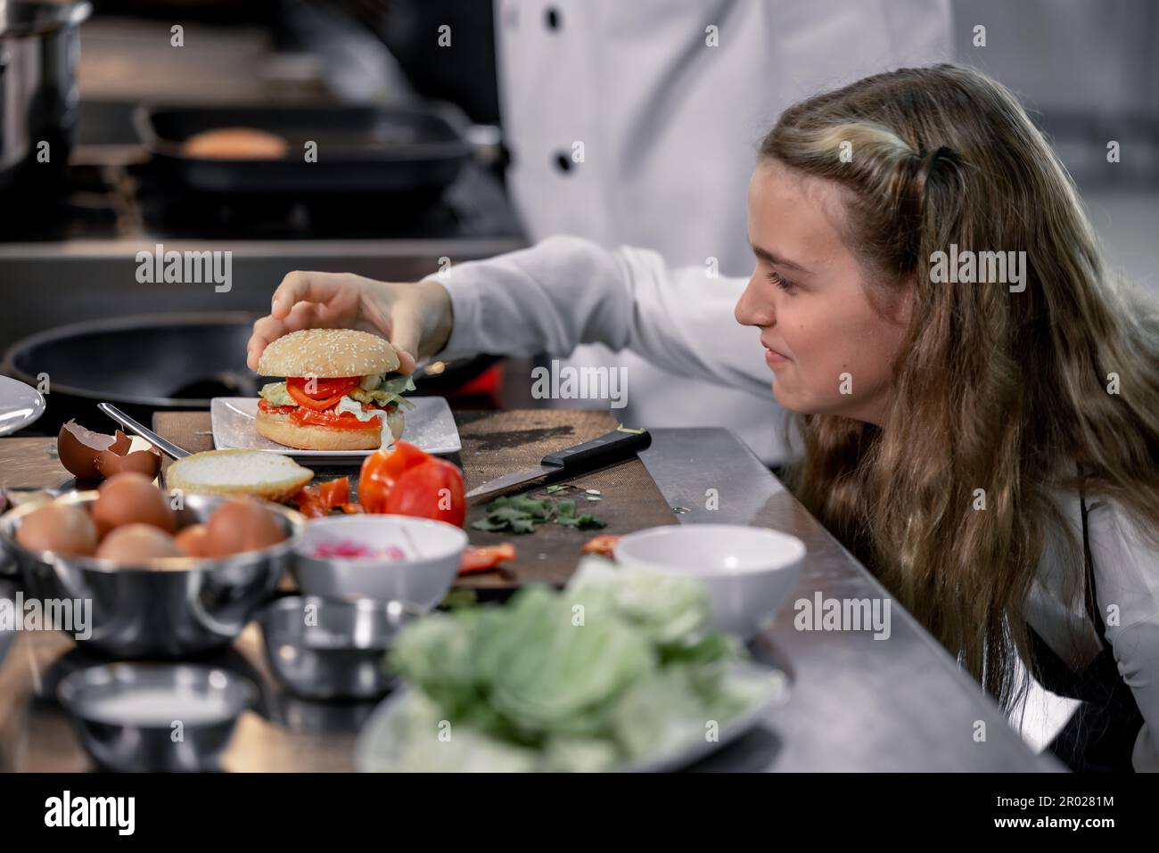 Les adolescents apprennent par des chefs experts de l'école culinaire à préparer des ingrédients et à créer une variété de plats savoureux. Une activité pratique a relié leur Banque D'Images