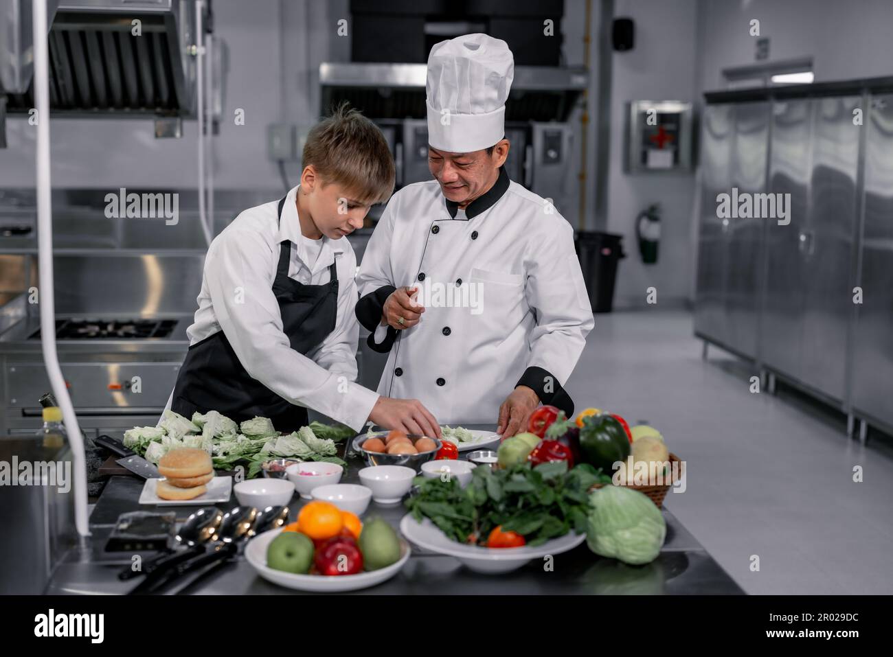Les adolescents apprennent par des chefs experts de l'école culinaire à préparer des ingrédients et à créer une variété de plats savoureux. Une activité pratique a relié leur Banque D'Images