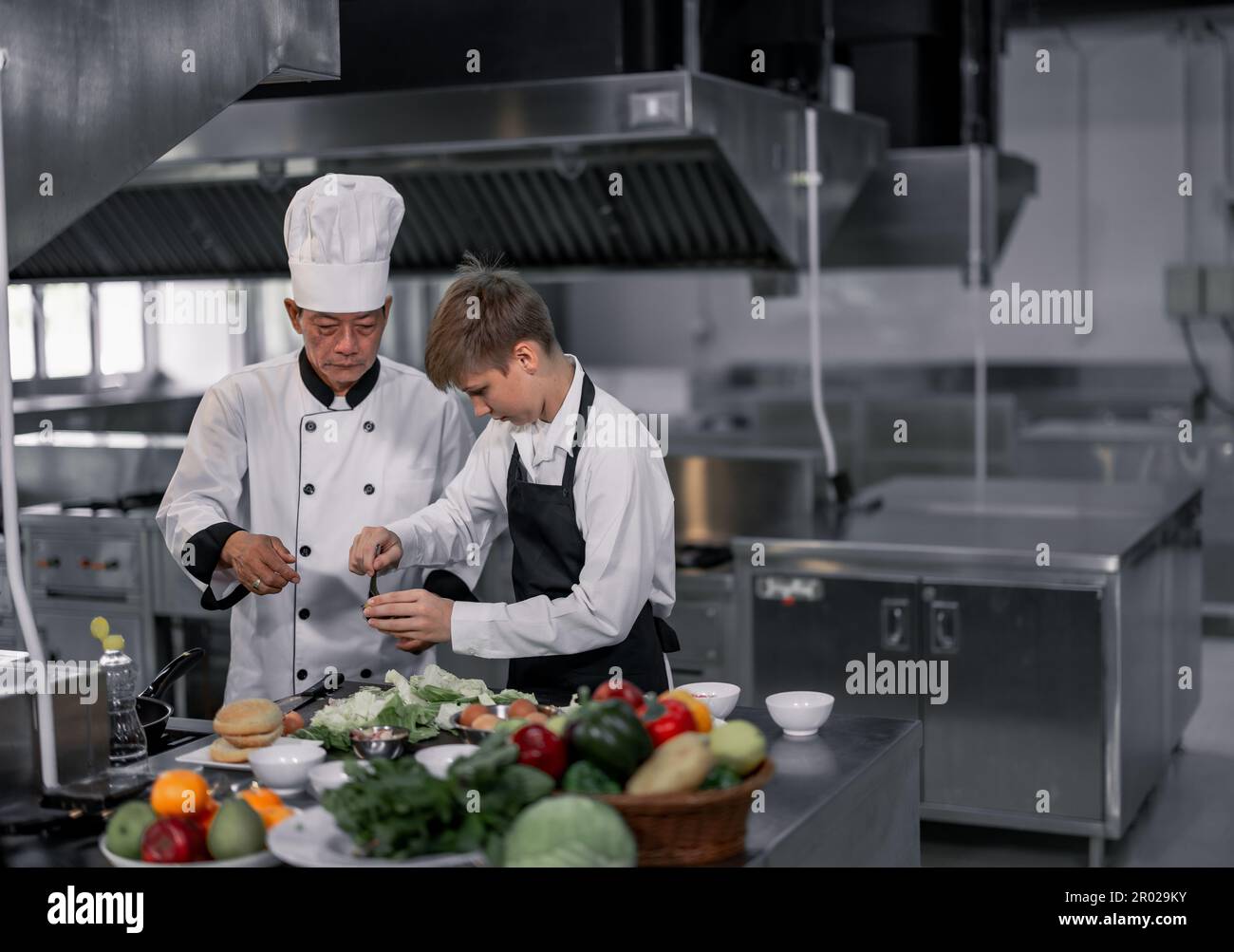 Les adolescents apprennent par des chefs experts de l'école culinaire à préparer des ingrédients et à créer une variété de plats savoureux. Une activité pratique a relié leur Banque D'Images