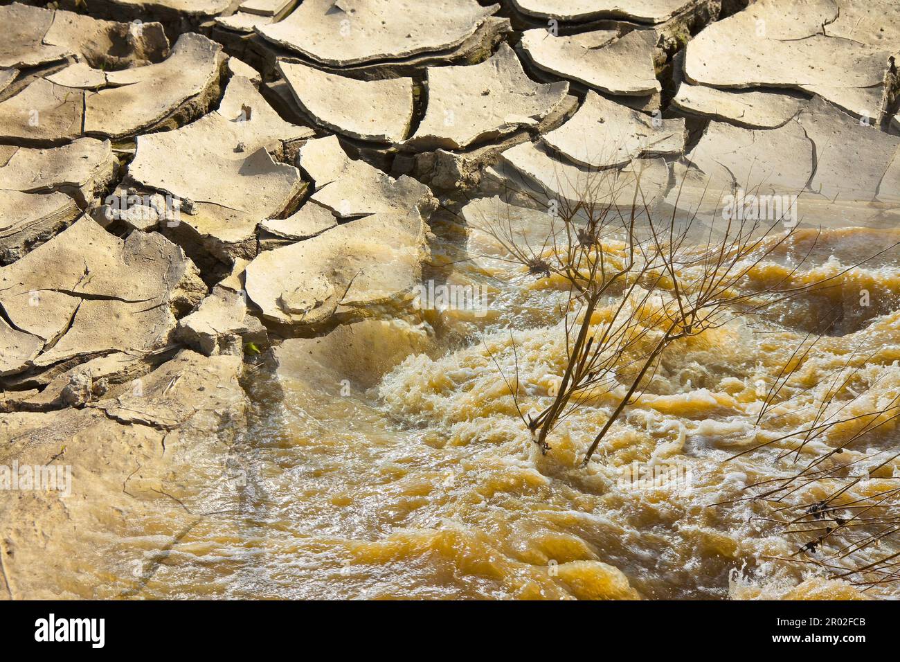 Les eaux qui font rage et le murmure après plusieurs jours de pluie versus terre infertiles brûlée par le soleil - image concept Banque D'Images