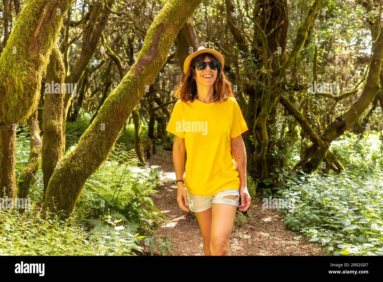 Femme touristique marchant dans le parc naturel de la Llania à El Hierro, îles Canaries. Sur un chemin de Laurier d'El Hierro dans un paysage verdoyant Banque D'Images