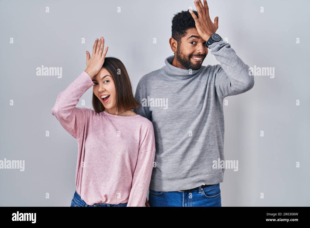 Un jeune couple hispanique debout ensemble surpris par la main sur la tête pour l'erreur, souvenez-vous de l'erreur. oubli, mauvais concept de mémoire. Banque D'Images Un jeune couple hispanique debout ensemble surpris par la main sur la tête pour l'erreur, souvenez-vous de l'erreur. oubli, mauvais concept de mémoire. Banque D'Images