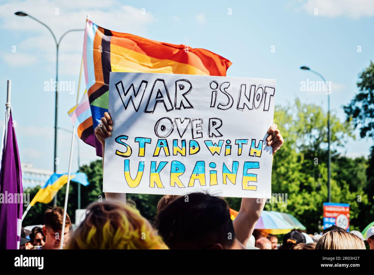 Fierté gay, la marche de solidarité LGBTQ avec des drapeaux arc-en-ciel et des affiches antiguerrières. Mains tenant une affiche avec des affiches antiguerrières. Défilé de l'égalité. Varsovie, Pologne Banque D'Images