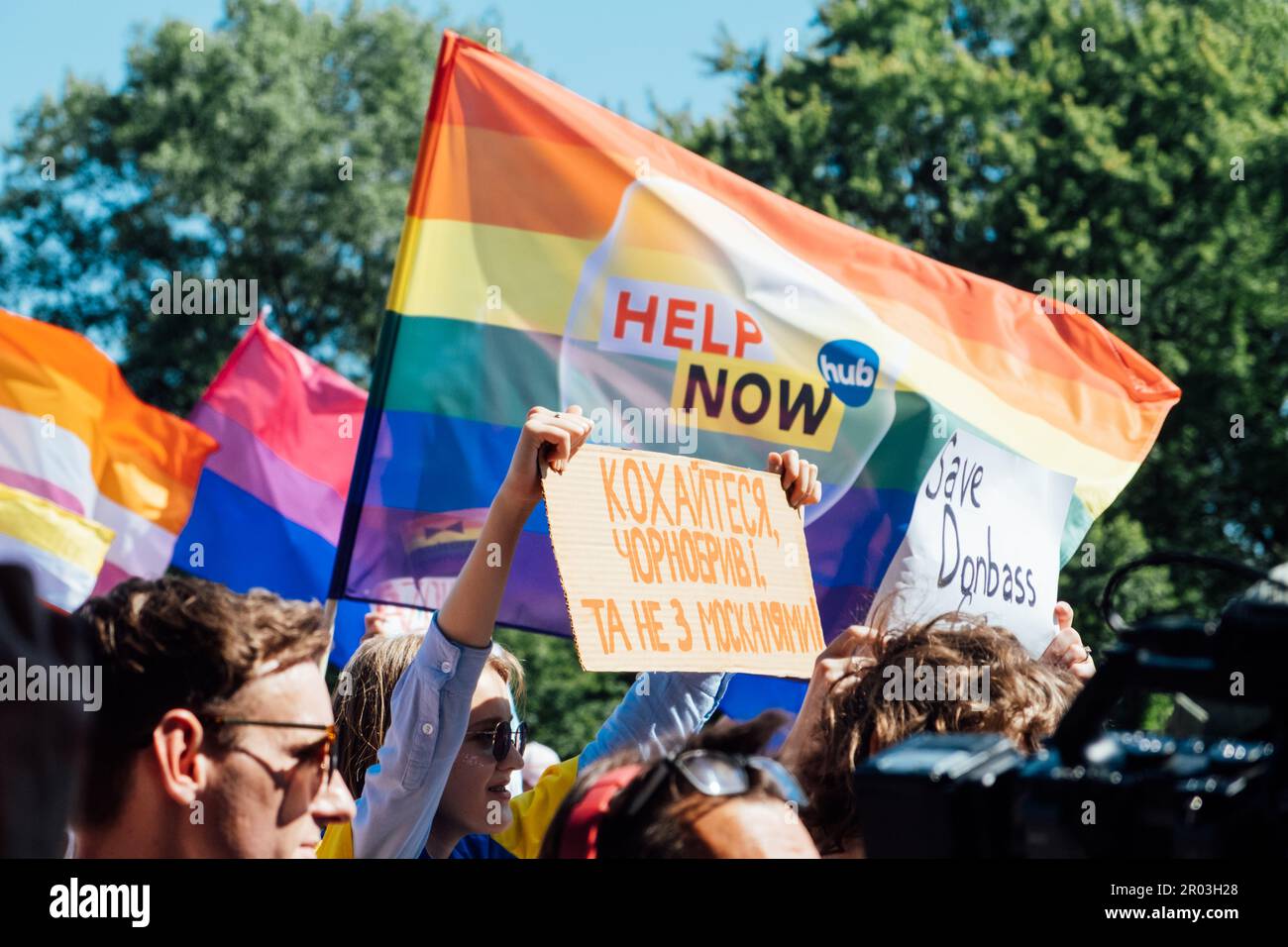 Fierté gay, la marche de solidarité LGBTQ avec des drapeaux arc-en-ciel et des affiches antiguerrières. Mains tenant une affiche avec des affiches antiguerrières. Défilé de l'égalité. Varsovie, Pologne Banque D'Images