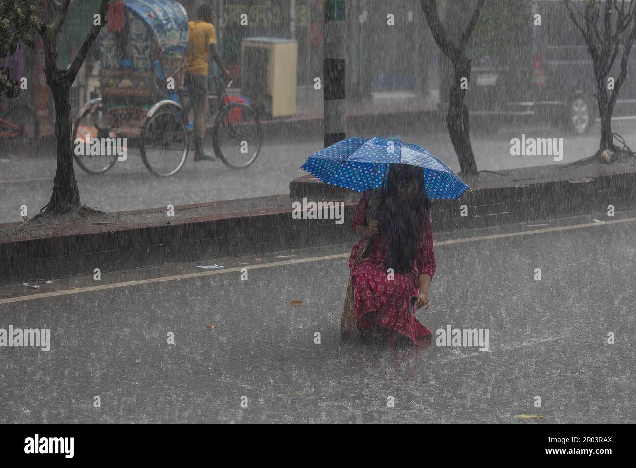 Dhaka, Bangladesh. 6th mai 2023. Une femme tient un parapluie tout en marchant le long de la rue un jour de pluie. La forte baisse de la mousson a rendu les déplacements lents et dangereux. (Credit image: © Sazzad Hossain/SOPA Images via ZUMA Press Wire) USAGE ÉDITORIAL SEULEMENT! Non destiné À un usage commercial ! Crédit : ZUMA Press, Inc./Alay Live News Banque D'Images