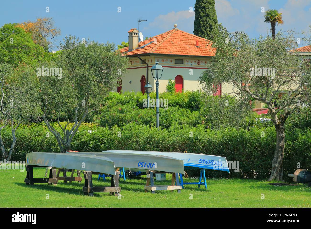 Trois bateaux séchant dans le jardin d'une maison sur le lac de Garde en Italie Banque D'Images