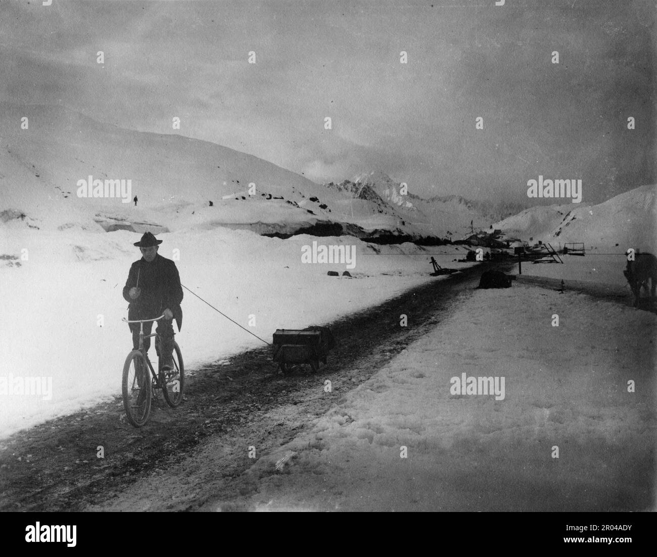 Un homme sur un vélo tirant un traîneau près du sommet de White Pass Trail, ca. 1899. Le col blanc était l'un des principaux itinéraires utilisés par les prospecteurs qui se rendent de Skagway aux champs aurifères du Yukon. Banque D'Images