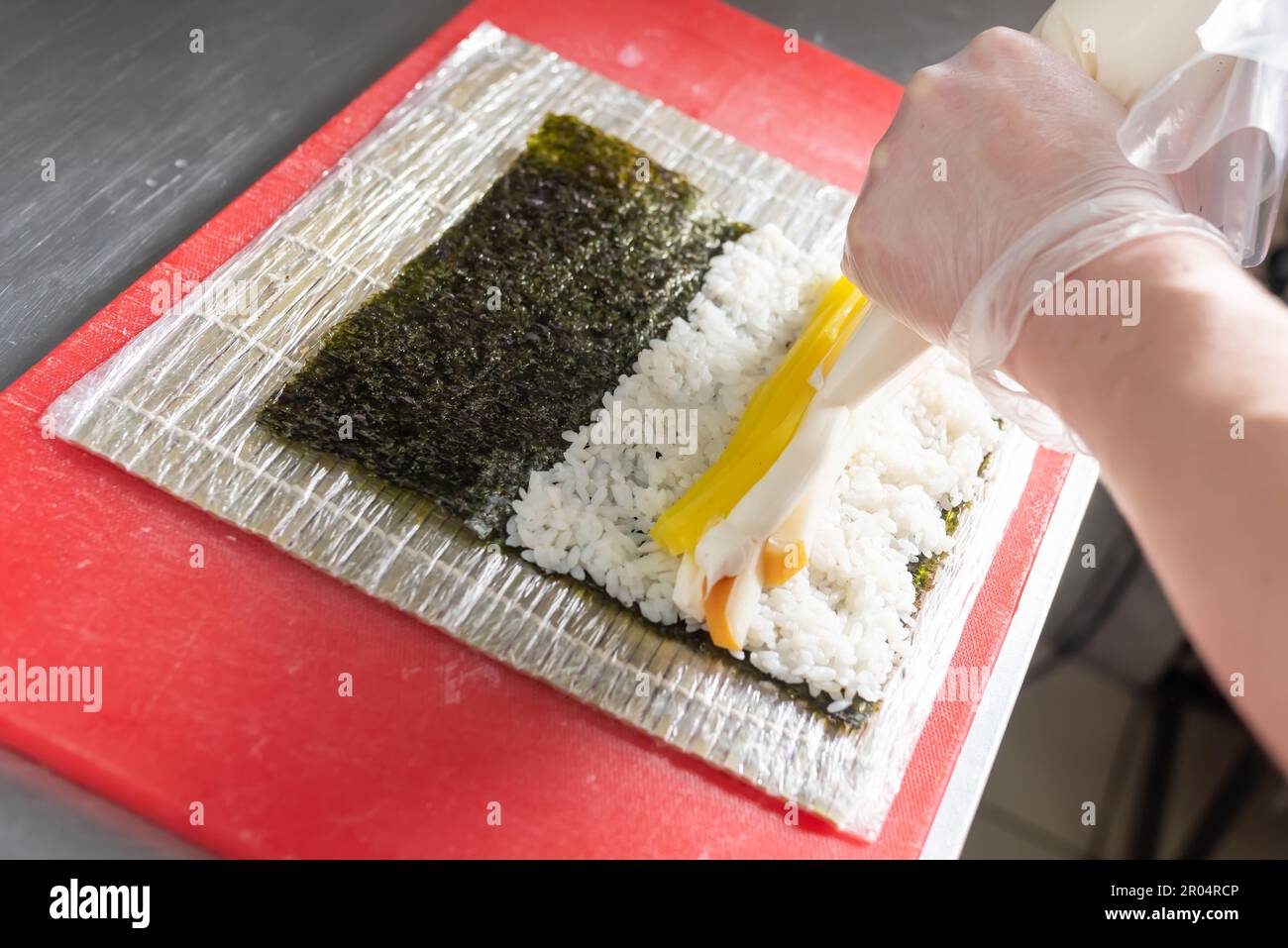 Faire cuire des sushis avec du daikon, du fromage et du calmar fumé. Photo de haute qualité Banque D'Images