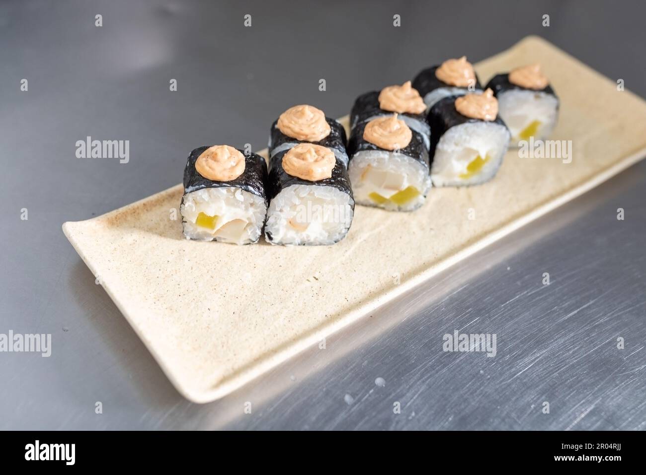 Sushi au fromage, daikon et calmar, sauce épicée, sur un tableau blanc. Photo de haute qualité Banque D'Images