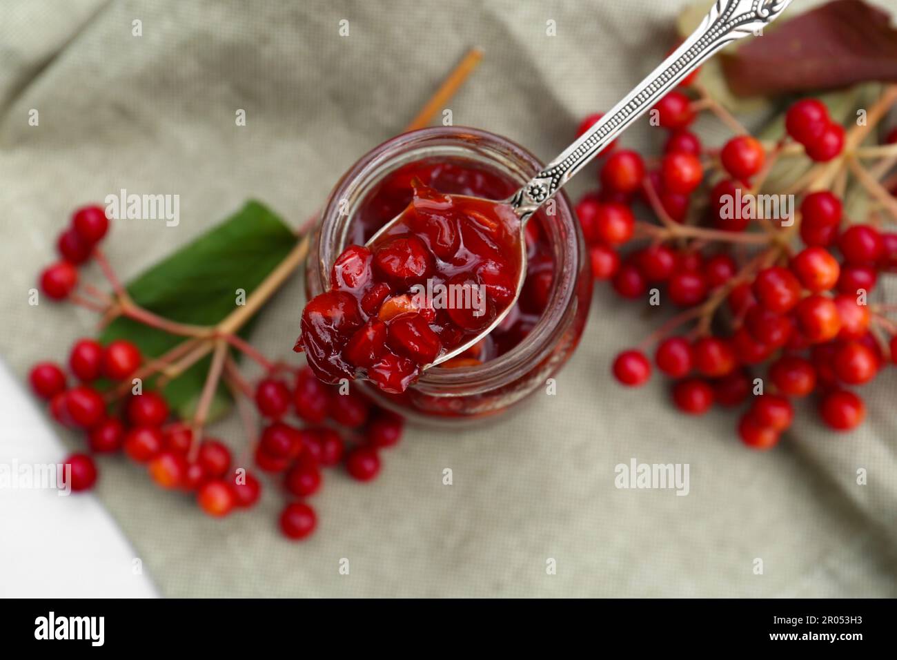 Cuillère et bol avec confiture de viburnum savoureuse sur la table, vue de dessus Banque D'Images