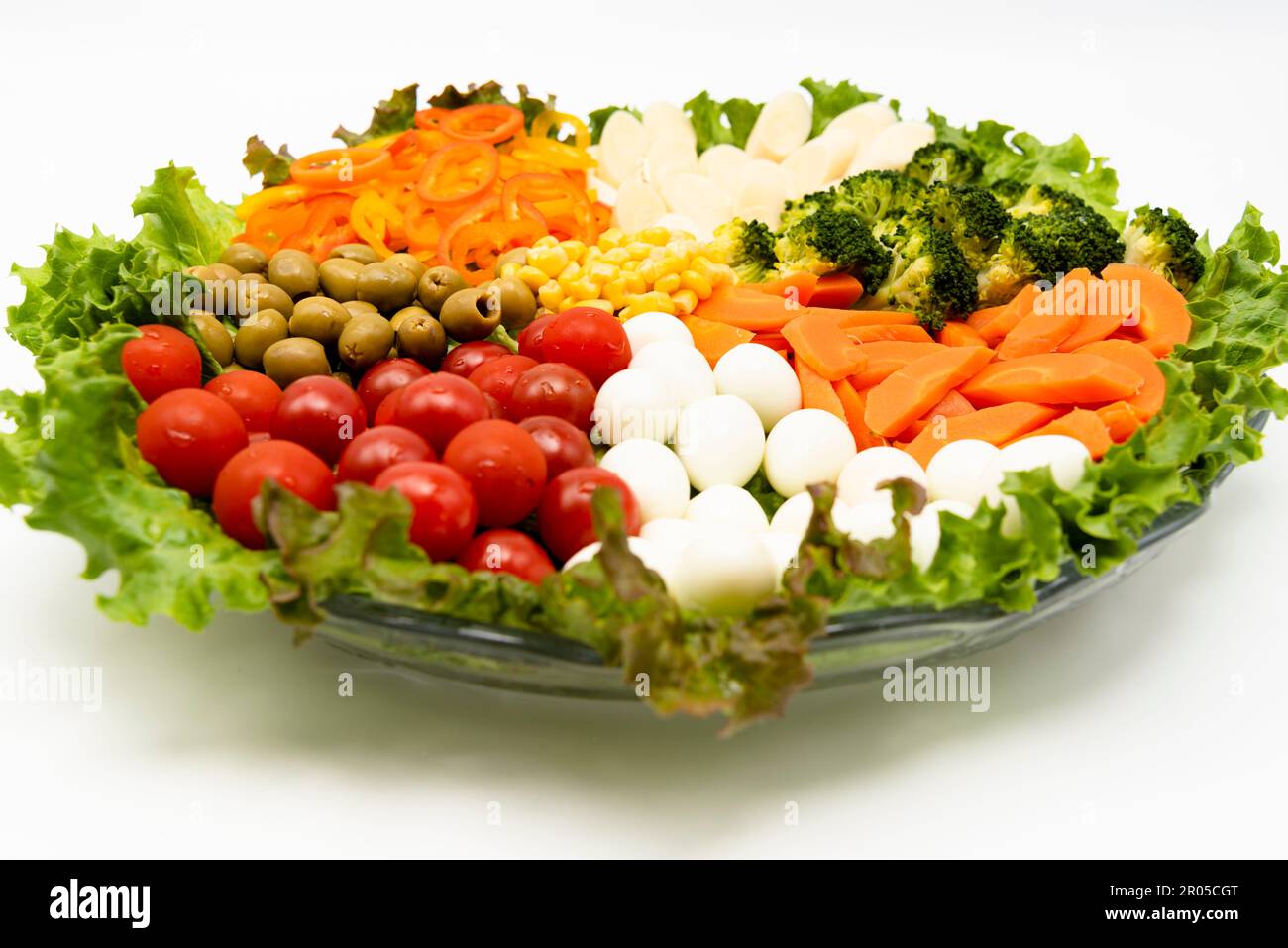 Salade de laitue délicieuse et saine avec divers légumes et œufs de caille isolés sur fond blanc dans la vue latérale. Banque D'Images
