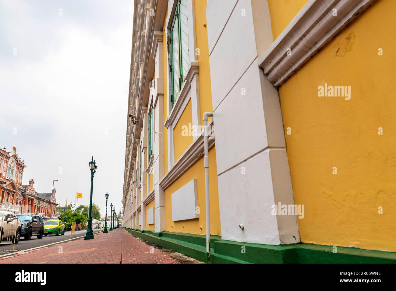 Bangkok,Thaïlande - 16 avril 2023: Le bâtiment jaune contraste avec les bandes blanches et a des fenêtres vert clair du Ministère thaïlandais de la défense. Banque D'Images