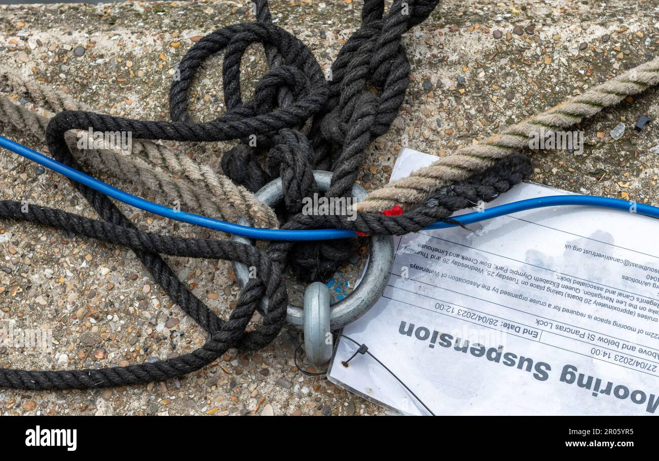 Londres. ROYAUME-UNI- 05.04.2023. Cordes liées à une amarrage sur le canal Regent's avec un avis de suspension d'amarrage. Banque D'Images