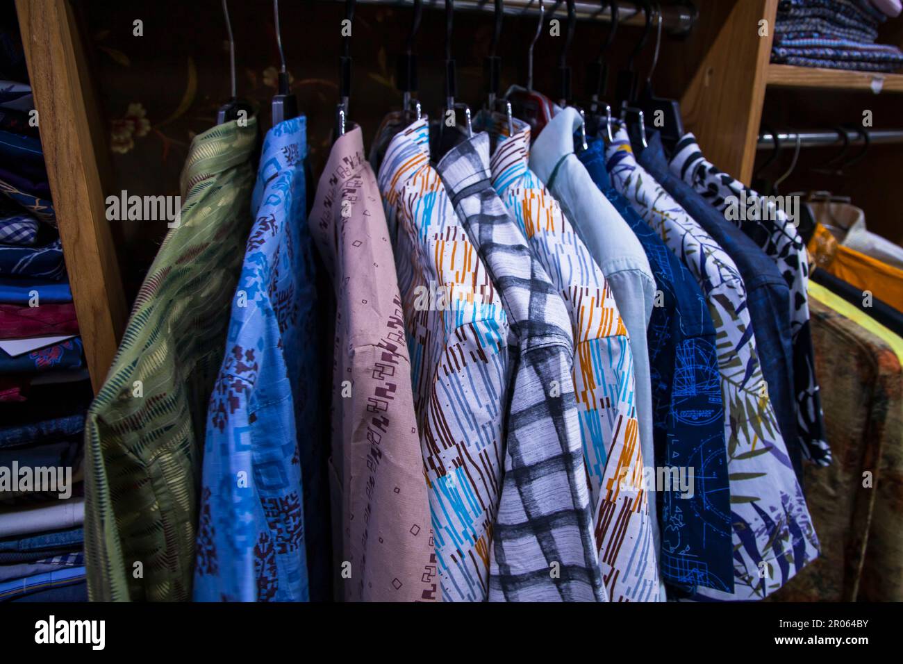 Variété colorée de tentures de chemises dans une salle d'exposition de vêtements. Mise au point rapprochée Banque D'Images