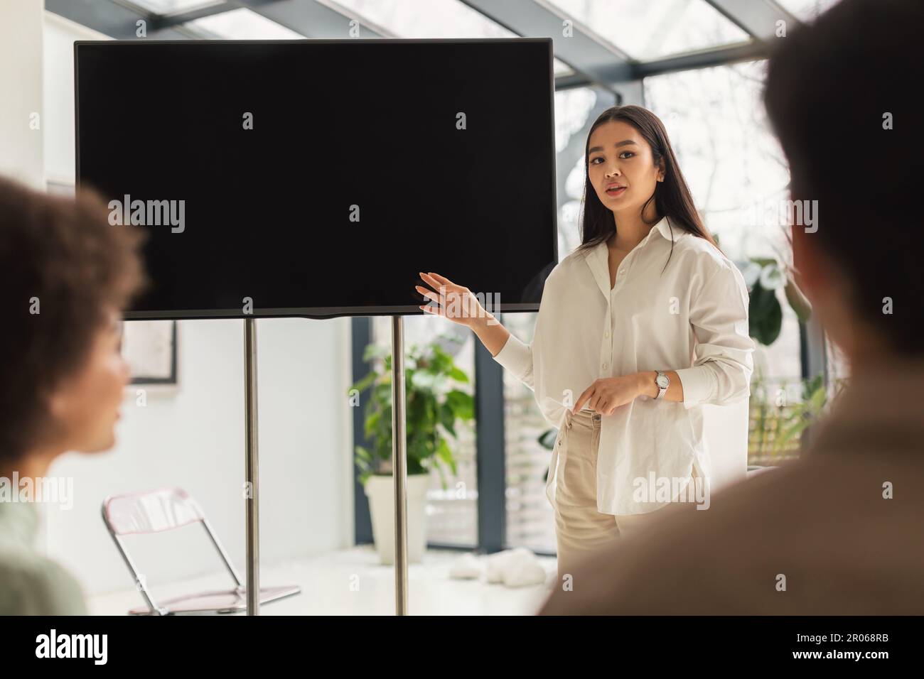 Femme d'affaires asiatique présentant des idées d'affaires pointant vers l'écran dans Office Banque D'Images