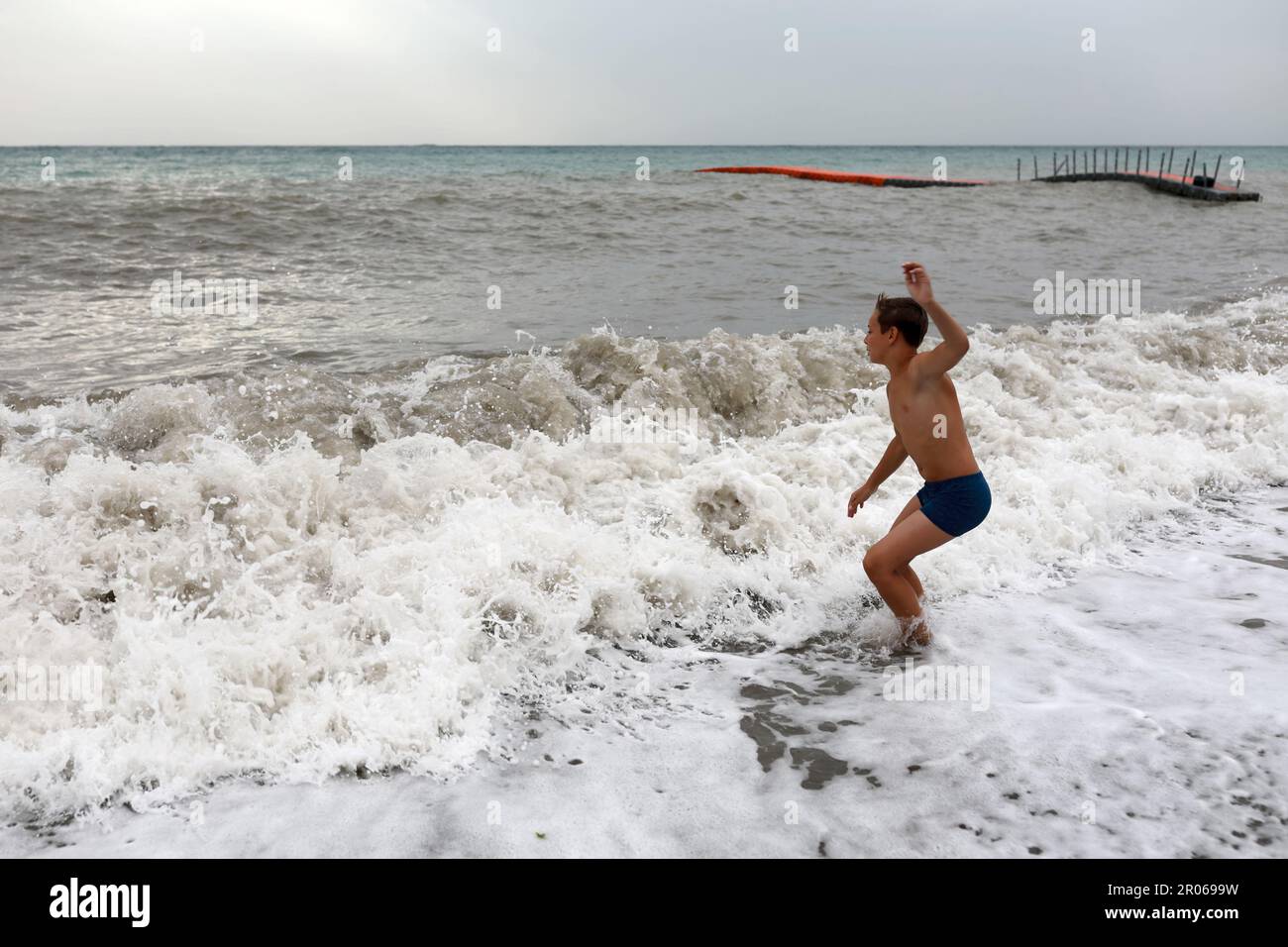 Garçon sur le rivage de la mer Noire orageux, Crimée Banque D'Images