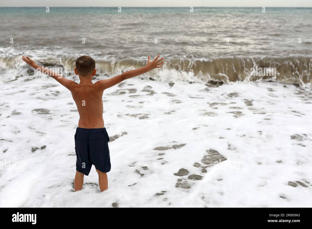 Enfant sur le rivage de la mer Noire orageux, Crimée Banque D'Images