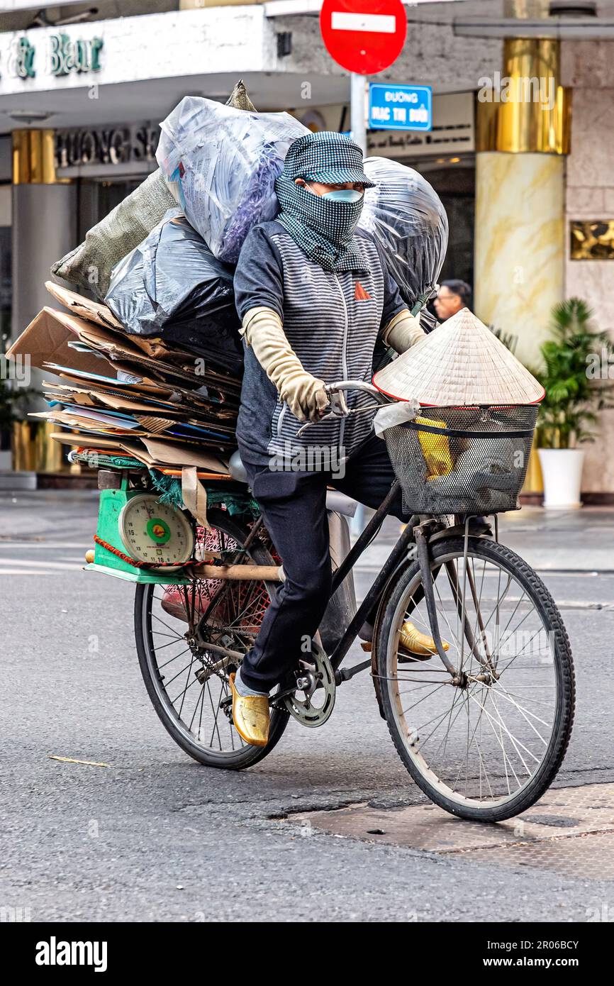 Dame vietnamienne avec masque et chapeau de bambou, recyclage des déchets à vélo, Ho Chi Minh ville, Vietnam Banque D'Images