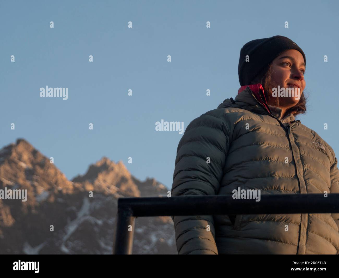 Brunette Backpacker Trekker avec chapeau polaire noir regardant à l'horizon pendant un hiver froid Himalayan jour. Banque D'Images