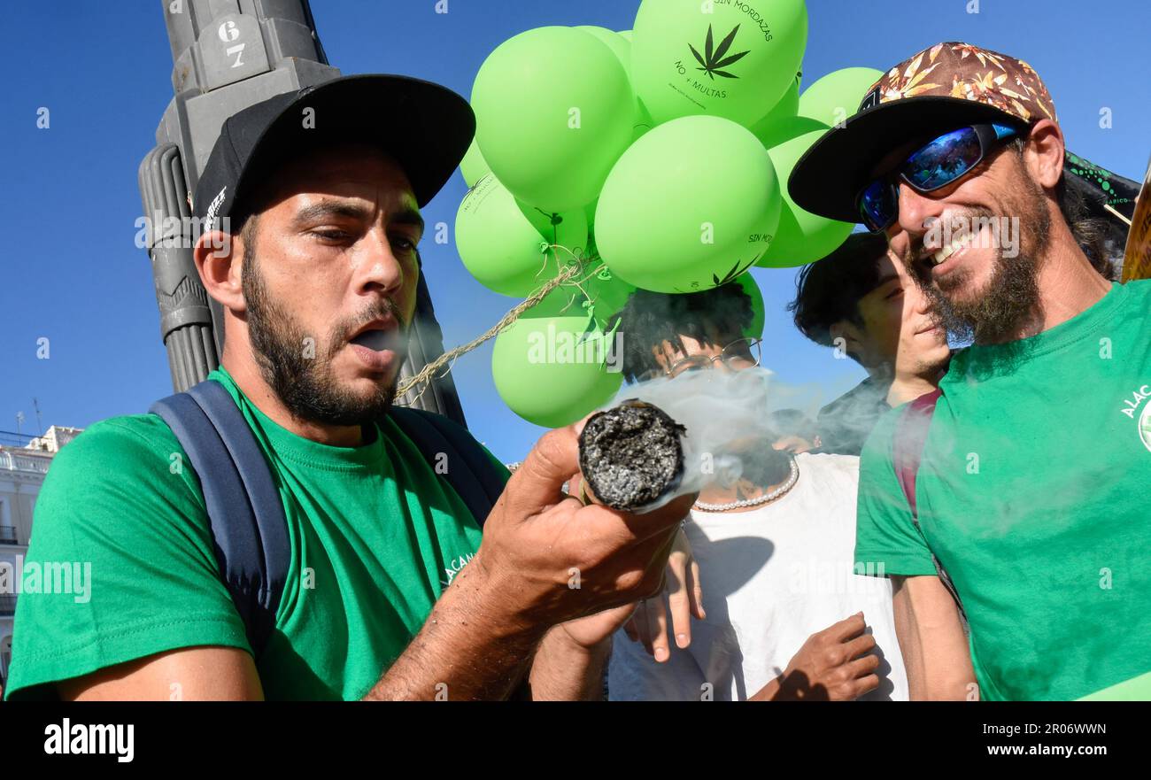 Madrid, Espagne. 06th mai 2023. Un jeune homme en transe après avoir fumé un joint géant de cannabis tandis qu'un autre jeune homme rit à côté de lui pendant la démonstration. La Marche mondiale de la marijuana de 2023 a rassemblé des milliers de personnes ce samedi dans le centre de Madrid, qui ont une fois de plus appelé à la légalisation du cannabis et ont revendiqué la nécessité d'établir un cadre réglementaire qui réglemente ce qu'ils considèrent comme une « réalité ». cela « ne peut pas être ignoré ». Crédit : SOPA Images Limited/Alamy Live News Banque D'Images