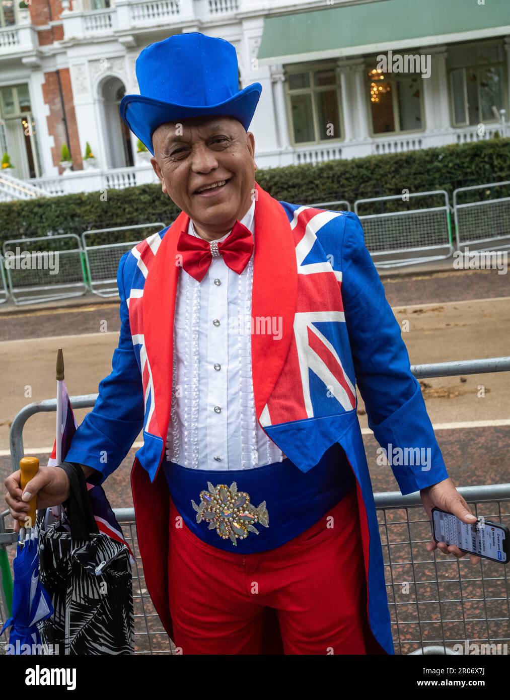 Un homme noir d'âge moyen vêtu d'un chapeau haut et d'une queue hauts en couleur, orné du drapeau syndical, se porte avec enthousiasme le jour du roi Charles III Banque D'Images