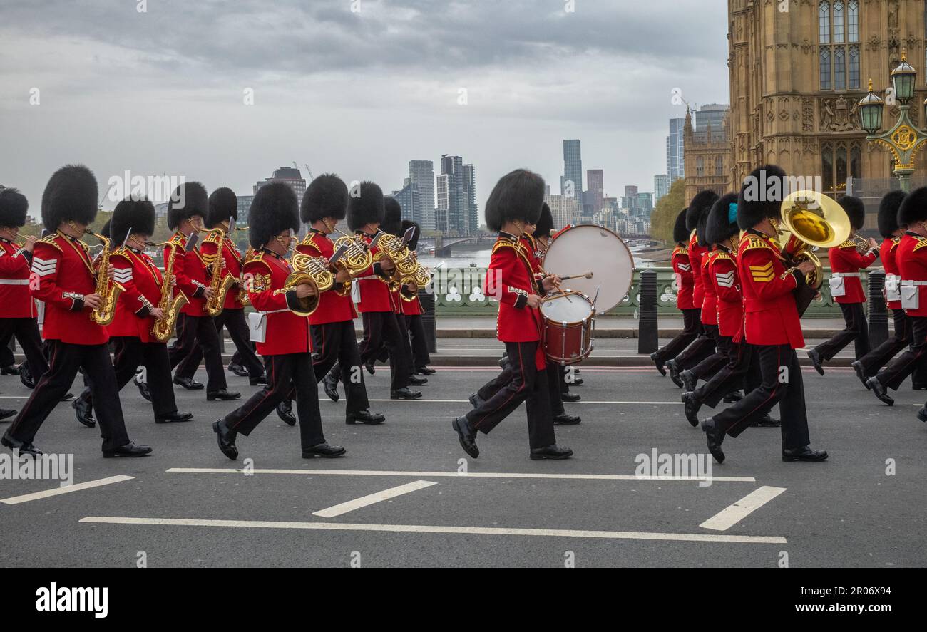 Alors qu'ils marchent en costume de cérémonie complet à travers le pont de Westminster, un groupe appartenant à la garde de Grenadier de l'armée britannique joue de la musique, comme ils marc Banque D'Images