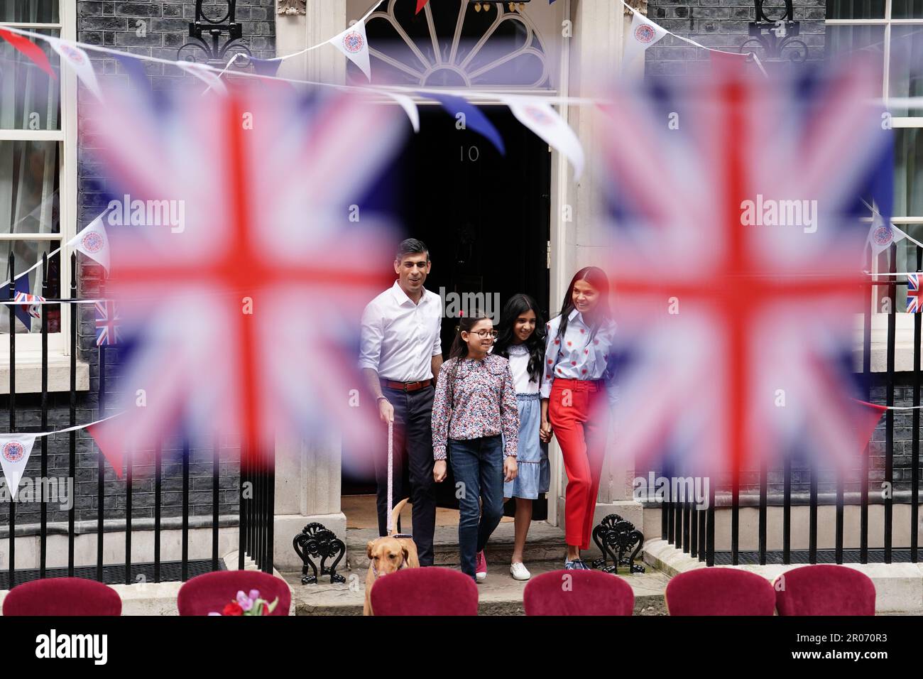 Le Premier ministre Rishi Sunak avec son chien Nova et sa femme, Akshata Murty, avec les enfants Krishna Sunak (au centre à gauche) et Anoushka Sunak, avant d'accueillir un grand déjeuner Coronation Big Lunch à Downing Street, Londres, pour des volontaires, des réfugiés ukrainiens au Royaume-Uni et des groupes de jeunes. Des milliers de personnes à travers le pays célèbrent le grand déjeuner de Coronation dimanche pour marquer le couronnement du roi Charles III et de la reine Camilla. Date de la photo: Dimanche 7 mai 2023. Banque D'Images