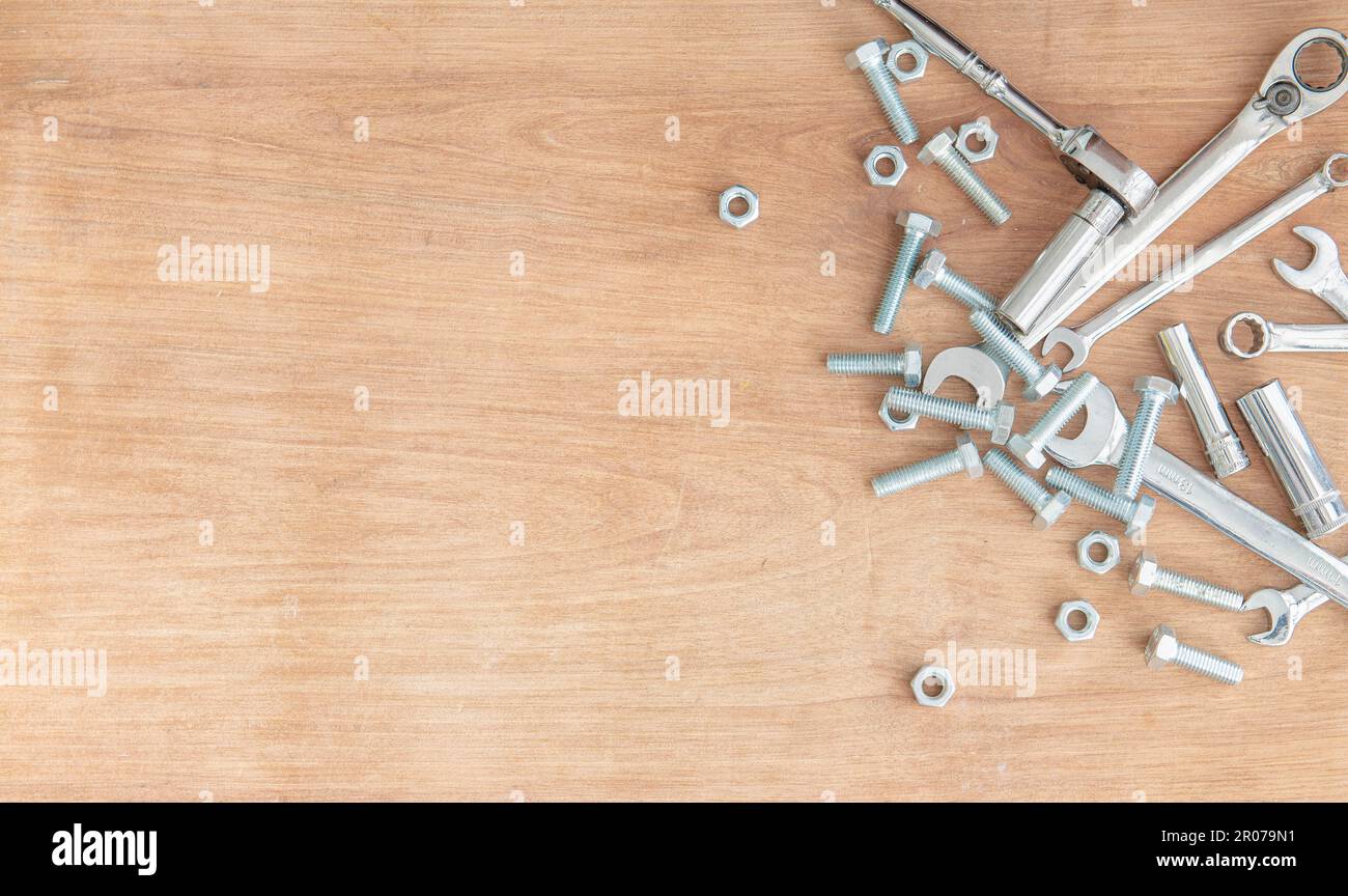 Clés et douilles avec écrous et boulons sur fond en bois. Banque D'Images