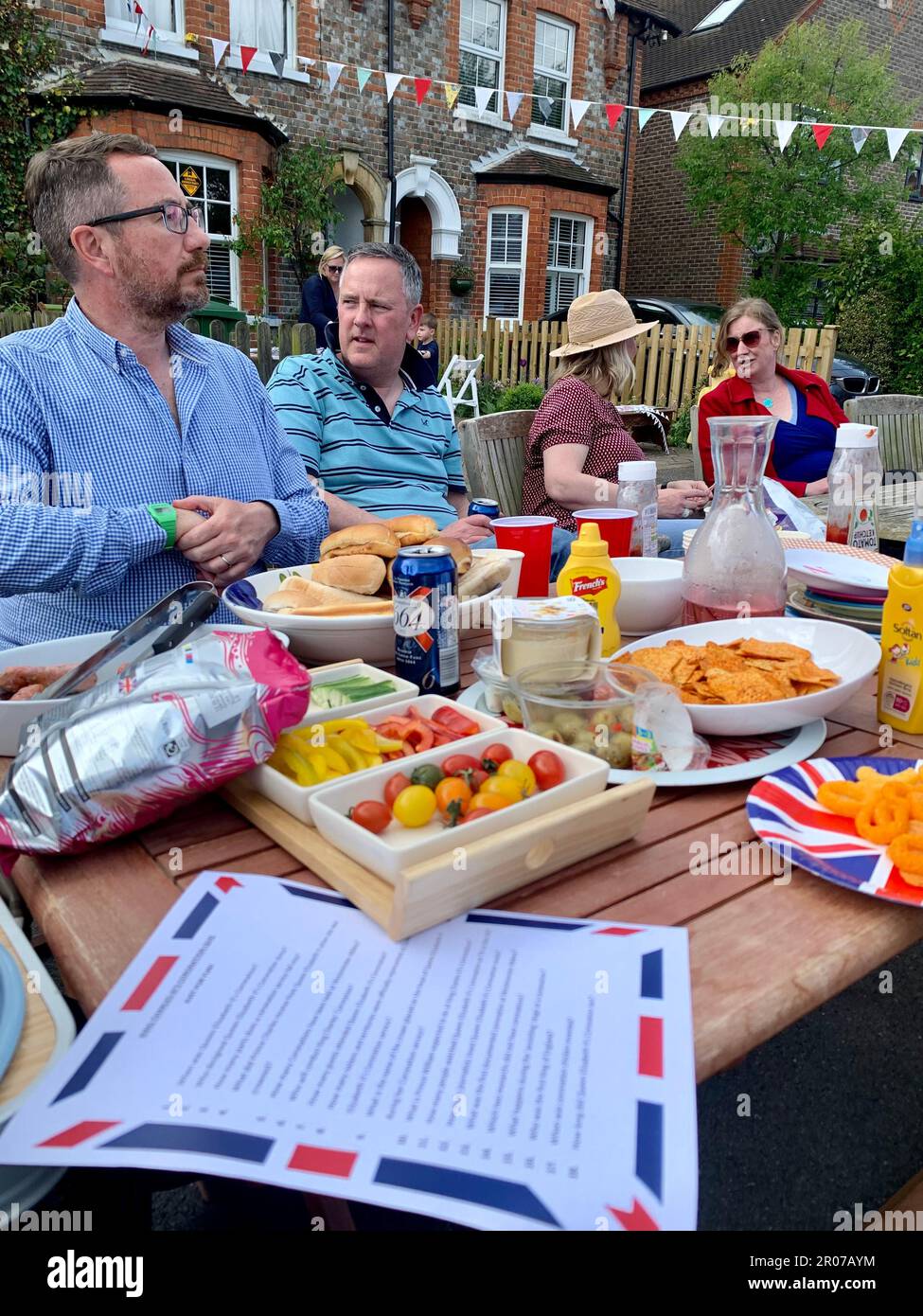 Non exclusif: Les résidents portant des couronnes participent au Coronation Big Lunch, dans le village de Pangbourne-on-Thames, lisant dans le Berkshire. Banque D'Images