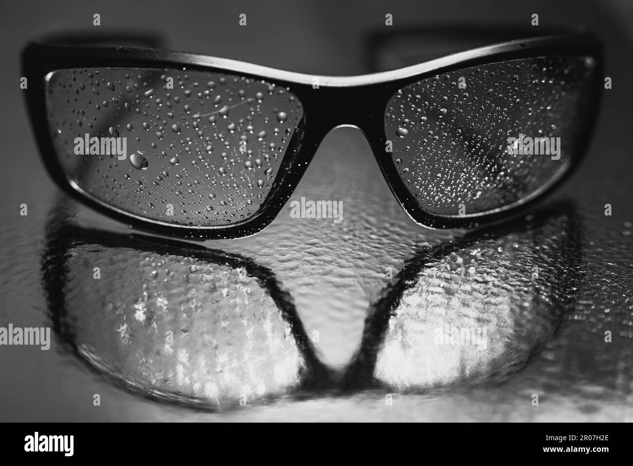 lunettes de soleil avec gouttelettes d'eau reflétées dans le miroir d'eau Banque D'Images