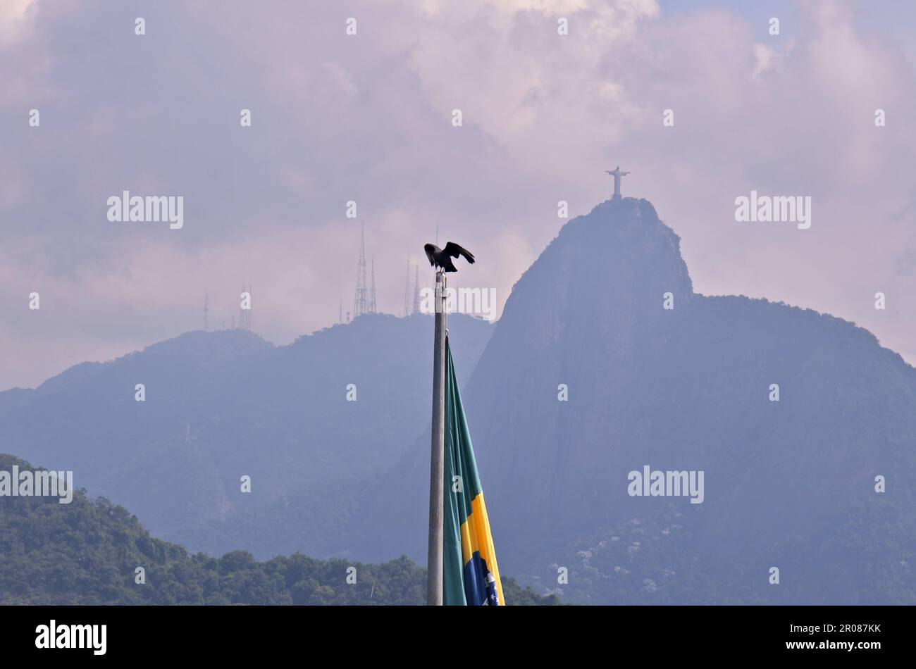 Rio de Janeiro/Brésil 05.06.2023: Drapeau du Brésil sur le mât et en arrière-plan Christ Rédempteur avec Rio de Janeiro favela dans la même scen Banque D'Images