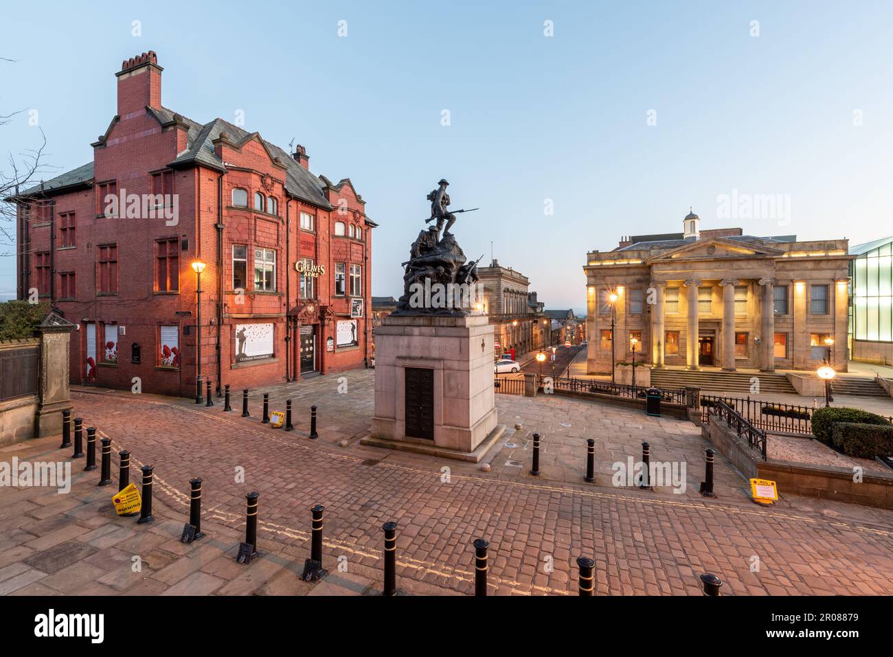 OLDHAM, Royaume-Uni-15 FÉVRIER 2019-vue éclairée de l'hôtel de ville dans une rue du Yorkshire avec la sculpture du mémorial de guerre à Oldham City, Royaume-Uni Banque D'Images