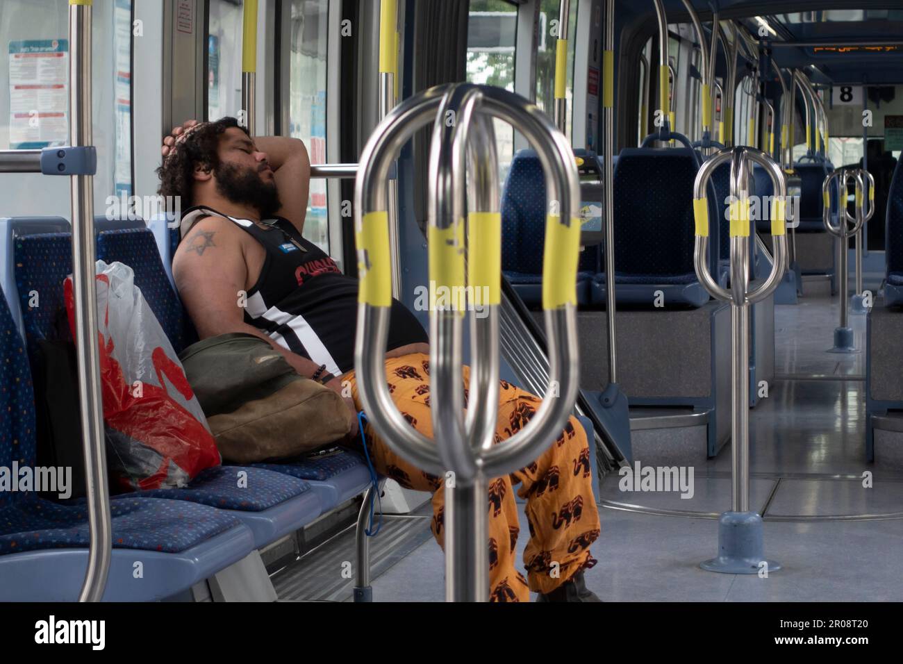 Un passager religieux juif avec l'étoile de David tatouage sur son bras dort alors qu'il roule le rail léger de Jérusalem ou le tramway de Jérusalem Israël Banque D'Images