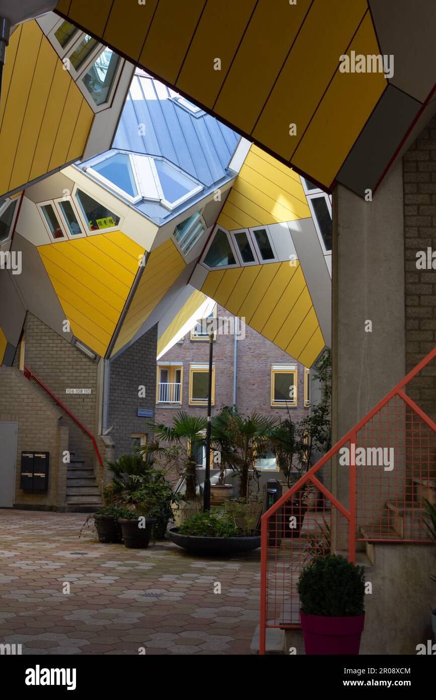 Rotterdam, NL, maisons cubiques conçues par Piet Blom, une cour intérieure avec des plantes, des escaliers et des détails rouges. Banque D'Images