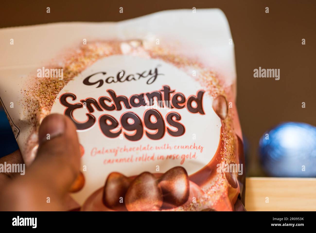 Un mâle adulte cueille un paquet d'œufs en chocolat sur la tablette de la maison Banque D'Images