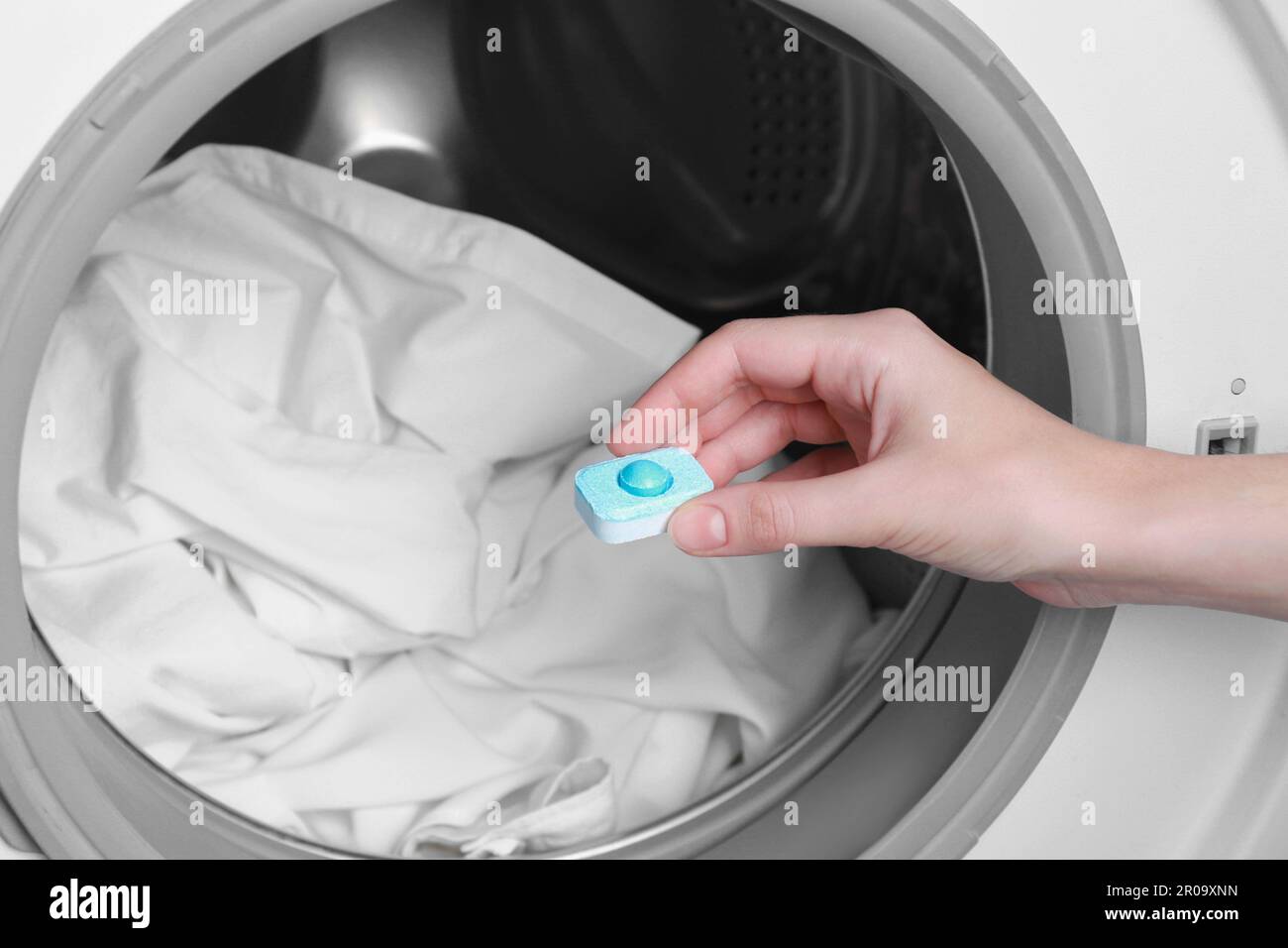 Femme mettant le comprimé adoucisseur d'eau dans la machine à laver, gros  plan Photo Stock - Alamy