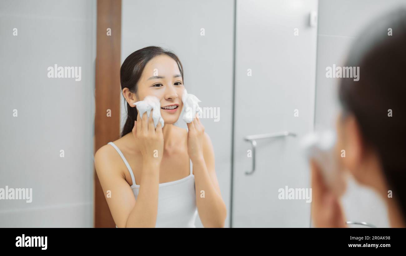Femme asiatique adulte nettoyage visage dans l'eau chaude à la maison le matin. Profitez d'un moment de détente. Banque D'Images