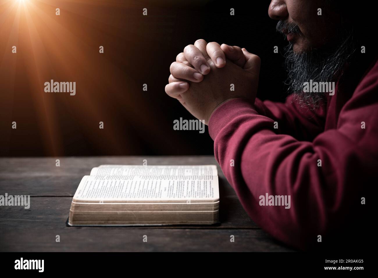 Les mains se sont repliées dans la prière sur une Sainte Bible dans le concept de foi, de spiritualité et de religion, l'homme priant le matin. Main d'homme avec la Bible prier. PE Banque D'Images