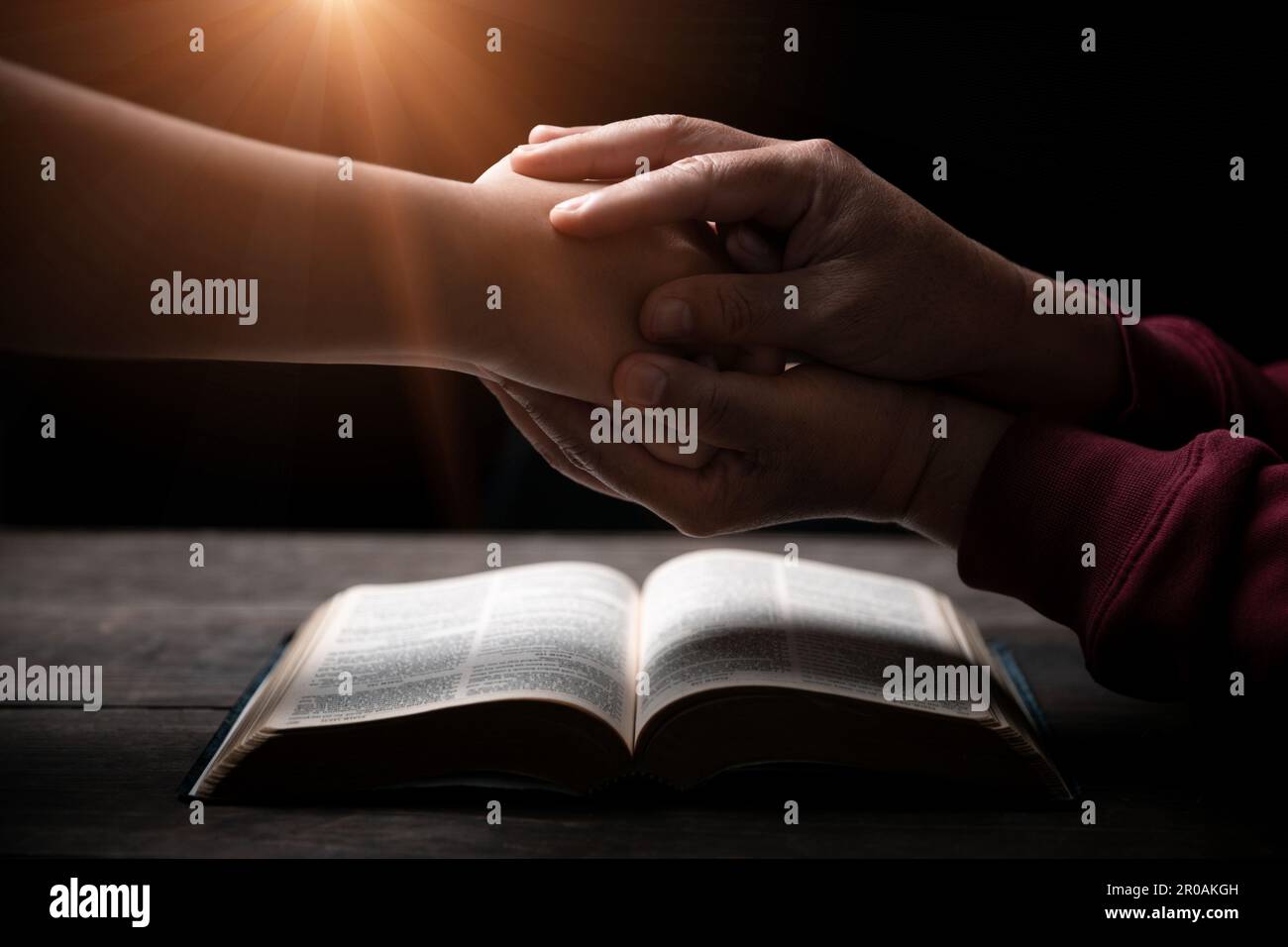 Les mains se sont repliées dans la prière sur une Sainte Bible dans le concept de foi, de spiritualité et de religion, l'homme priant le matin. Main d'homme avec la Bible prier. PE Banque D'Images