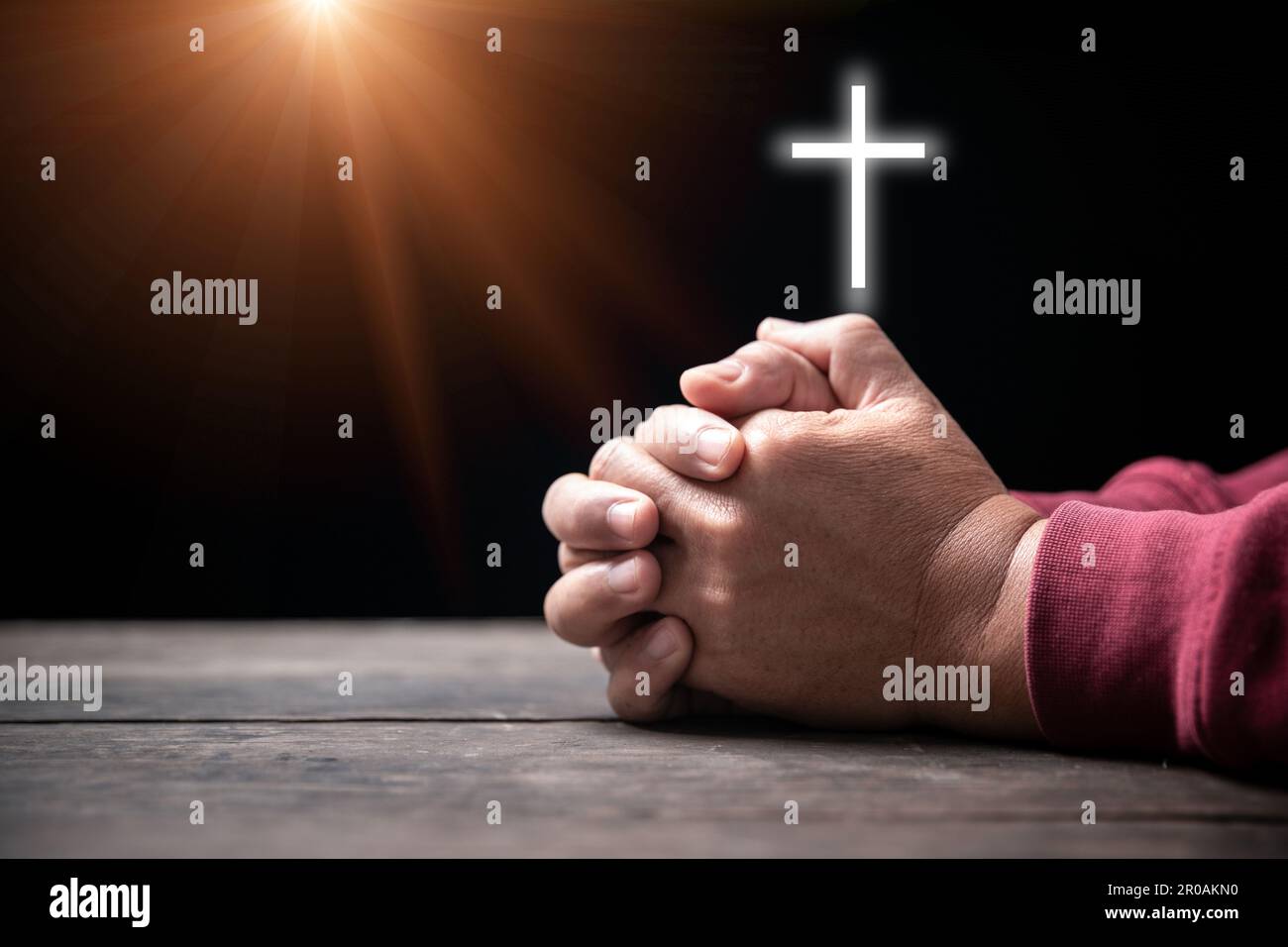 Les mains repliées dans la prière sur la Sainte Bible avec la croix dans le concept d'église pour la foi, la spiritualité et la religion, l'homme priant sur la sainte bible sans crucifix en mœurs Banque D'Images