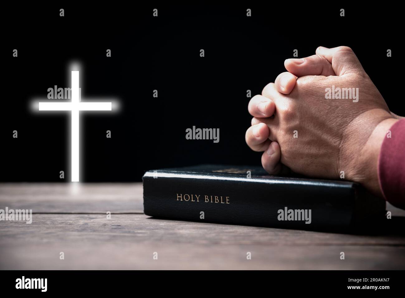 Les mains repliées dans la prière sur la Sainte Bible avec la croix dans le concept d'église pour la foi, la spiritualité et la religion, l'homme priant sur la sainte bible sans crucifix en mœurs Banque D'Images