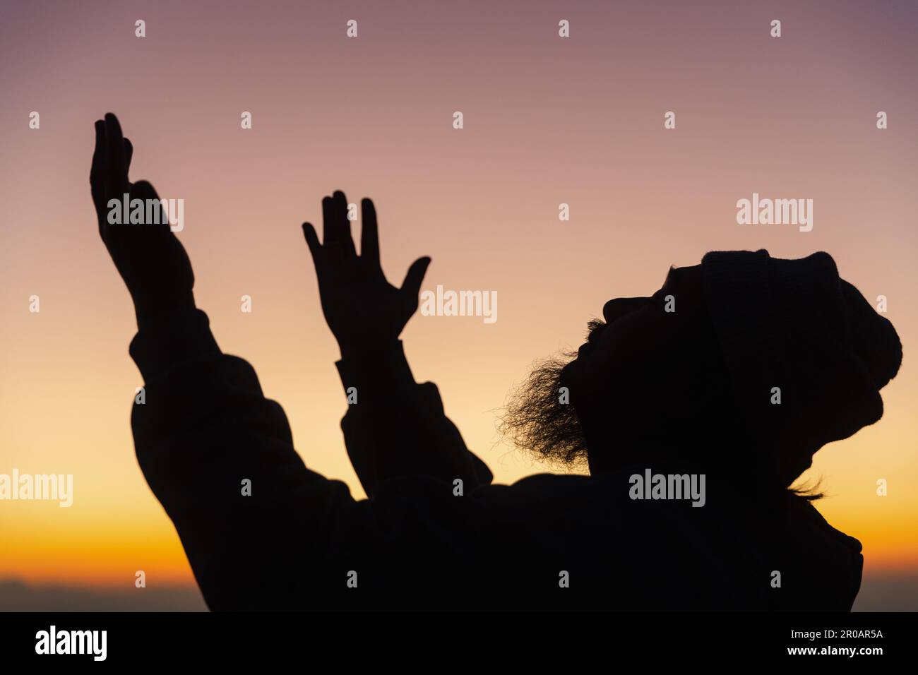 Silhouette de l'homme s'agenouillant en priant pour l'adoration de Dieu sur fond de ciel. Les chrétiens prient à jésus-christ pour le calme. Le matin, les gens sont arrivés à une quil Banque D'Images