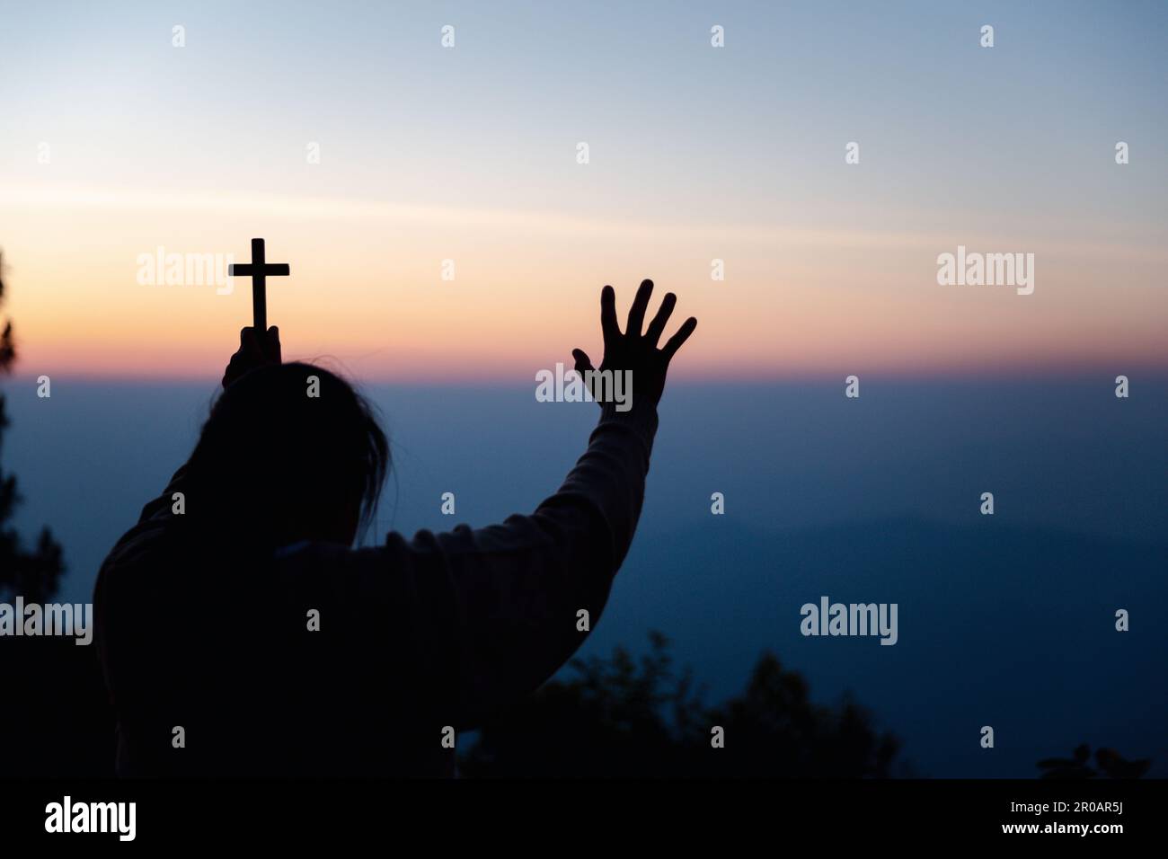 Silhouette de femme s'agenouillant en priant pour l'adoration de Dieu sur fond de ciel. Les chrétiens prient à jésus-christ pour le calme. "Le matin, les gens ont atteint un. Banque D'Images