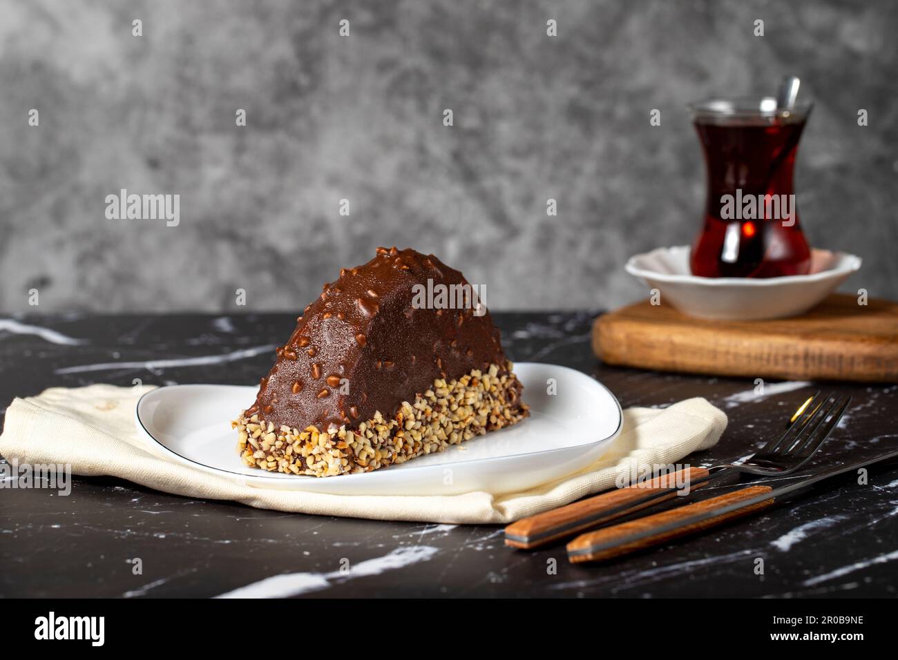 Gâteau à la banane et au chocolat. Gâteau de malaga recouvert de chocolat et noisette sur fond sombre. Banque D'Images