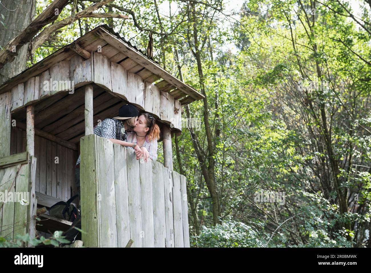 Un jeune couple embrasse une tour de guet dans une forêt, en Bavière, en Allemagne Banque D'Images
