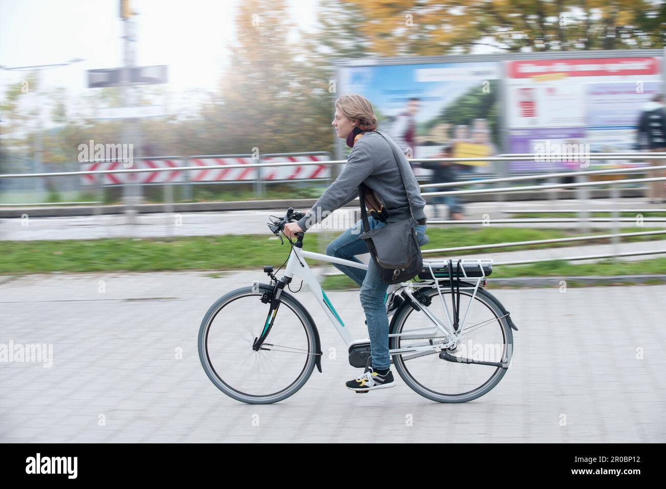 Adolescent à vélo sur la route de terre jusqu'à la gare, Bavière, Allemagne Banque D'Images