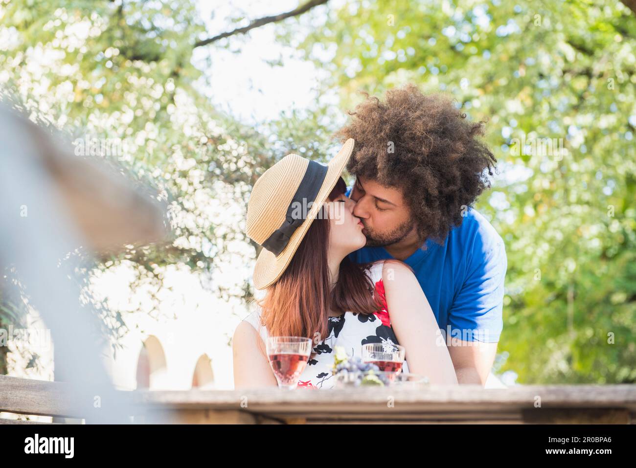Un jeune couple s'embrasse au restaurant en plein air Banque D'Images