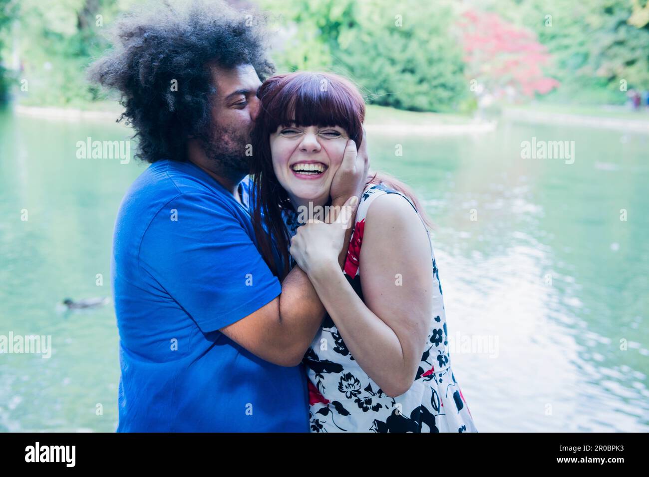 Homme embrassant femme à l'extérieur au bord du lac Banque D'Images